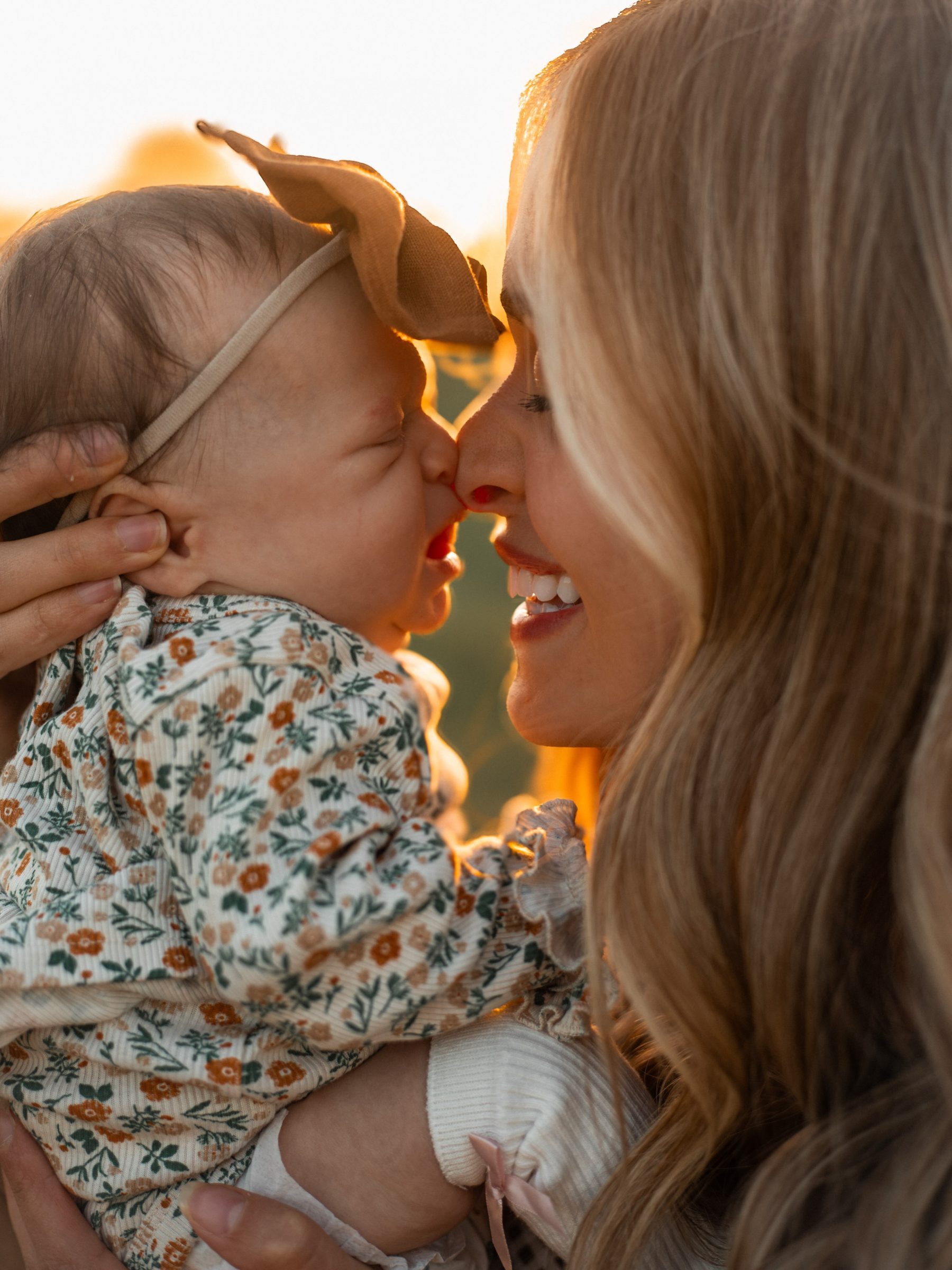 Mother and baby touching noses in warm natural light